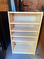 Front view of light maple engineered wood bookcase showing five shelves