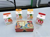 Front view showing three boxed vegetable timers and Aladdin tin