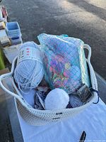 Basket containing assorted yarn skeins and accessories