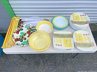 All items laid out on table showing variety of plates, bowls and packaged skewers