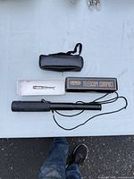 Monocular telescope with box, pouch, neck strap and lens caps displayed on table