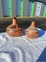 Both decorative gourds side by side on table outdoors