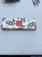 Closed presentation box with holly pattern