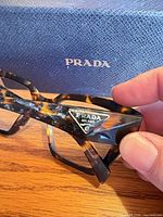 Close-up of Prada logo plaque on temple and tortoiseshell pattern