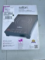 Front of boxed Salton induction cooktop showing model and power info