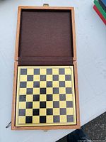 Open wood box showing black & gold board inside