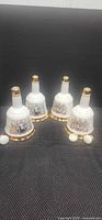 Four porcelain decanter bells with three stoppers displayed