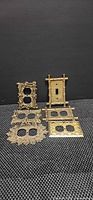 All six antique brass tone outlet and switch plates displayed together