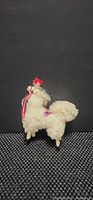 Front profile of wool alpaca figurine showing tassel and saddle