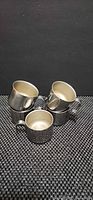 Group of five stainless steel demitasse cups stacked together