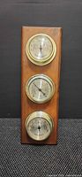 Front view showing three Taylor gauges on wood plaque