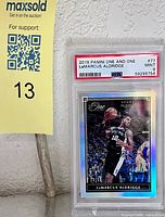 Front view of PSA-slabbed Aldridge card beside lot marker