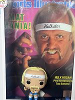 Front view showing Hulk Hogan figure positioned before Sports Illustrated "Mat Mania!" cover