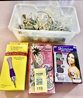 Plastic bin with broken jewelry/beads and three boxed items front