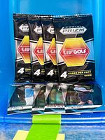 Four sealed Panini Prizm LIV Golf packs arranged vertically with four loose Prizm LIV Golf cards displayed below