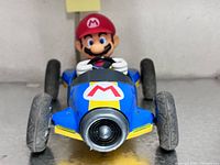 Front view Mario kart figurine showing hood logo and wheels