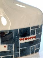 Close-up of blue-gray geometric band with red accents on bottle