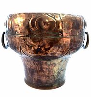 front view of hammered copper jardiniere showing floral band and ring handles