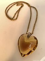 Necklace laid flat showing heart pendant shape, chain, clasp
