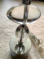 Full view of lamp base showing stacked glass elements, chrome base and clear cord