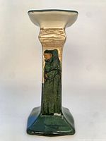 Full view of candlestick showing square column, hand-painted figure and green glaze