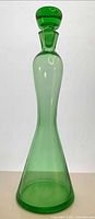 Full view of transparent green glass decanter with stopper