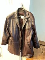Front view of leather car coat on hanger