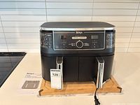 Front angle showing complete air fryer, control panel, baskets, power cord and manual