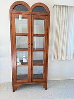 Front view showing double arched top, glass doors and overall style