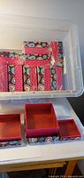 Stacked sets of patterned gift boxes inside storage bin