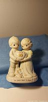 Front view of figurine showing boy and girl with cake