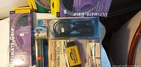 Group shot of packaged steering wheel covers, Wiper Wizard, extension cord, cup holder
