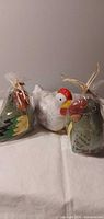 Front view of two sealed parrot candles and unwrapped hen candle