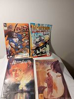 Group shot of the four comic books upright and flat