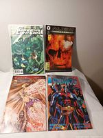 Group shot of four comic books: Green Lantern, Alien Resurrection, Camelot 3000 Book 8, Stormwatch #2