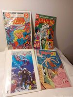 All four bagged comics displayed upright on table