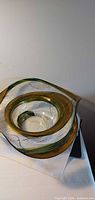 Top angle showing entire clear glass bowl with green-gold band and black accents