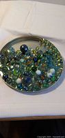 Wide view of marbles spread on metal jar lid