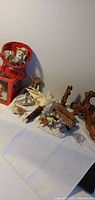 overview of assorted figurines, basket, tin, driftwood and shells