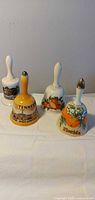 Four ceramic souvenir bells standing upright