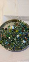 Top view of mason jar lid filled with assorted marbles