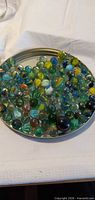 Overview of mixed marbles on metal lid