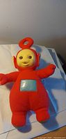 Front view of red Po talking plush showing face, tummy screen and overall condition