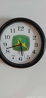 Front view of John Deere wall clock showing logo, numerals, hands