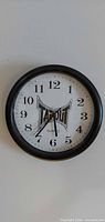 Front view of Tapout wall clock showing face, numerals and hands