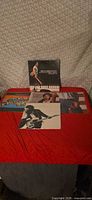 All five Bruce Springsteen albums laid out on red surface
