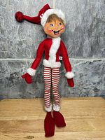 Full view of Annalee elf doll standing on wooden surface