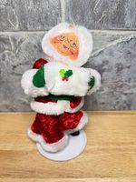 Front view of Annalee plush Santa holding white sack on felt base