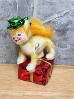 Full view of Annalee cat plush on red gift box