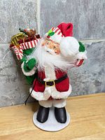 Front view of Santa figurine standing with sack of gifts